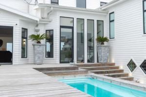 a home with a swimming pool and a house at Sandbanks Villa in Yzerfontein