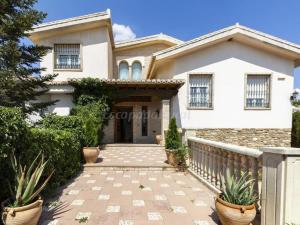 a white house with a fence and potted plants at Villa del Mamut, Padul Granada in Padul