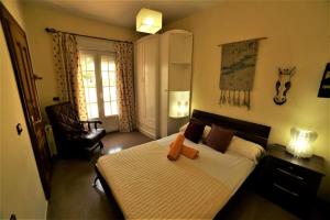 a bedroom with a large bed and a chair at Villa del Mamut, Padul Granada in Padul +53 photos