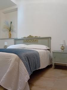 a bedroom with a bed with a blue and white bedspread at EMARI HOME in Gaeta