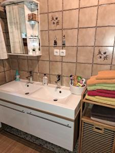 ein Badezimmer mit einem weißen Waschbecken und einem Spiegel in der Unterkunft Maria's Ferienwohnung in Laakirchen