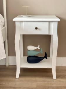 a white bedside table with a stuffed whale under it at Piso familiar cerca de playa in Pobra do Caramiñal