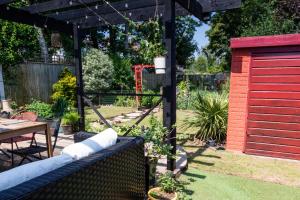 a garden with a pergola and a red shed at Pass the Keys Spacious Characterful Home in Bournemouth