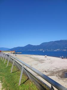a fence on a beach next to the water at Residenza al Lago in Germignaga