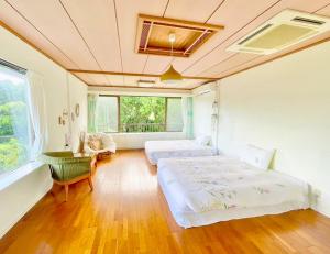 石垣島的住宿－イリワ -stay&coffee iriwa-，一间卧室设有两张床、一张桌子和一个窗口。