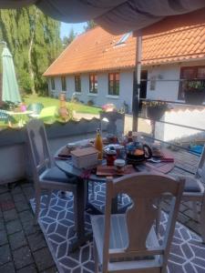 une table et des chaises assises sur une terrasse dans l'établissement KRAGKAER Deer-Lodge B&B A unique holiday home, à Sæby