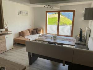 a living room with a couch and a table at Ferienwohnung Praißkopf Blick in Pfunds
