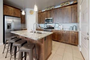 a kitchen with wooden cabinets and a kitchen island with stools at Southern Comfort-Pool! Hot Tub! in Washington