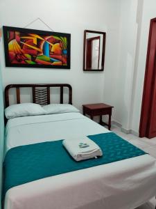 1 dormitorio con 1 cama con una pintura en la pared en Hotel Las Vegas by Marbar Hoteles, en Santa Marta