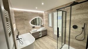 エルバルンガにあるAppartement exceptionnel, vue mer, climatiséのバスルーム(バスタブ、洗面台2台、シャワー付)
