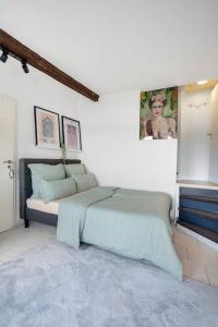 a bedroom with a bed and a painting on the wall at Tiny apartment with spacious terrace on the Rhine in Neuwied
