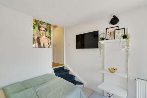 a bedroom with a bed and a tv on a wall at Tiny apartment with spacious terrace on the Rhine in Neuwied