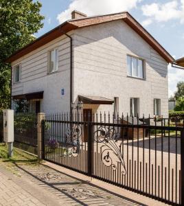 a house with a wrought iron fence in front of it at LULU GAST HAUS in Ventspils