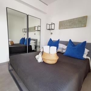 Schlafzimmer mit einem Bett mit blauen und weißen Kissen in der Unterkunft Il Volo in Sperlonga
