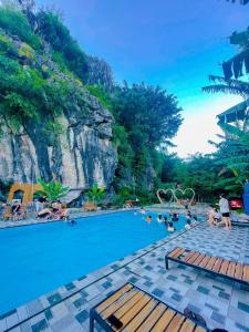 a pool at a resort with people in the water at Ham Rong Bungalow in Xuân Sơn