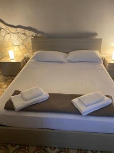 サレルノにあるb&b Green Valleyのベッド1台(白いタオル2枚、ランプ2つ付)