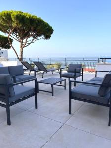 une rangée de bancs assis sur une terrasse près de l'océan dans l'établissement Il Volo, à Sperlonga