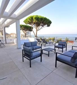 - un ensemble de chaises assises sur une terrasse donnant sur l'océan dans l'établissement Il Volo, à Sperlonga