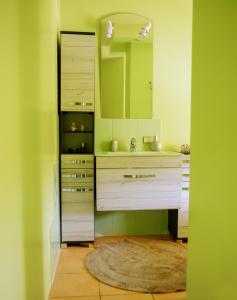 een badkamer met een wastafel en een spiegel bij LULU GAST HAUS in Ventspils