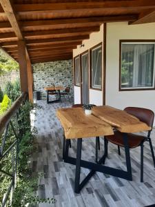 einen Holztisch und Stühle auf einer Terrasse in der Unterkunft La Piticu in Dubova