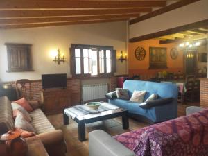 a living room with couches and a coffee table at La Casa del Abuelo Simón in Fuente el Sauz