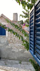 an old building with a blue door and some flowers at Villa rustica bougainvillea in Maslinica