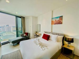 a bedroom with a white bed and a large window at Edge Central Pattaya Vip Condo in Pattaya Central