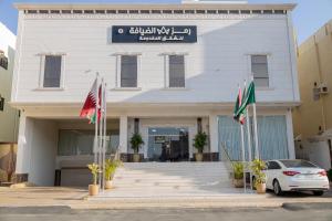 a white building with flags in front of it at Ramz Al Diyafa 2 in Taif
