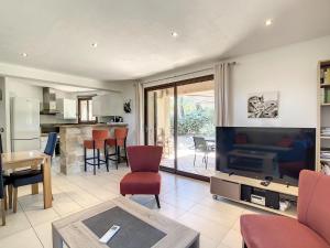 a living room with a flat screen tv and a living room at La Petite Bergerie in Le Plan-de-la-Tour