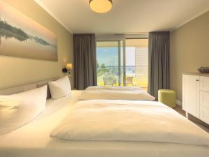 two beds in a bedroom with a view of the ocean at Appartements "Zum Leuchtturm" Hafen Rankwitz Insel Usedom in Rankwitz