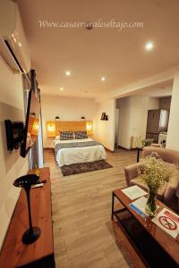 a hotel room with a bed and a living room at Casas Rurales El Tajo in Setenil