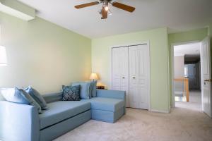 a living room with a blue couch and a ceiling fan at Star of the Sea guest house in White Rock