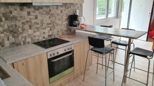 een keuken met een fornuis en een aanrecht met krukken bij Angela's Luxury Apartments in Kamena Vourla