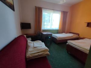 レバルにあるJODA Pokoje Goscinneのベッド2台と窓が備わるホテルルームです。