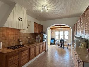 uma cozinha com armários de madeira e uma mesa num quarto em Maison Noirmoutier-en-l'Île, 4 pièces, 6 personnes - FR-1-224B-198 em Noirmoutier-en-l'lle