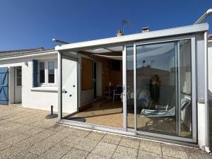 uma extensão a uma casa com portas de vidro deslizantes em Maison Noirmoutier-en-l'Île, 4 pièces, 6 personnes - FR-1-224B-198 em Noirmoutier-en-l'lle