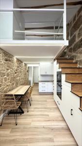 uma cozinha com uma mesa e uma parede de pedra em Celanova House em Celanova