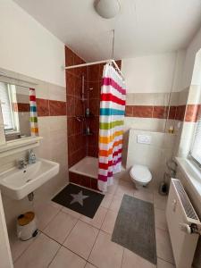a bathroom with a rainbow shower curtain and a sink at Apartment in Frankfurt
