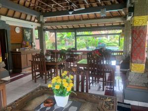 een eetkamer met stoelen en een tafel met bloemen bij Dewa Bharata Bungalows Ubud in Ubud
