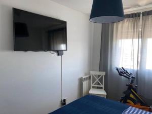 1 dormitorio con 1 cama azul y TV en la pared en Lisboa Deluxe Apartment - Parque das Nações, en Lisboa