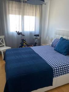 Un dormitorio con una cama azul y blanca y una bicicleta en Lisboa Deluxe Apartment - Parque das Nações, en Lisboa