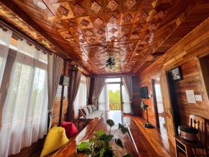 a living room with a wooden ceiling and a table at Mountain House Phú Quốc in Phu Quoc