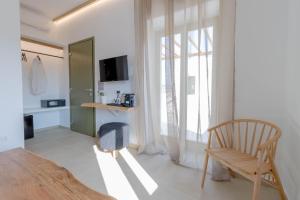 una camera con tavolo, sedia e finestra di ALIRENE MYKONOS a Panormos - Mykonos