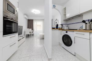 una cucina bianca con lavatrice e asciugatrice di Calle Concordia 86, two bedroom apartment, up to 6 guests, near Del Cura beach,supermarket Mercadona and central bus station a Torrevieja
