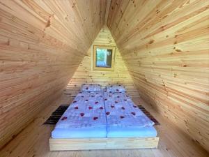 1 cama en una habitación de madera en una cabaña en ECO River Camp en Radovljica