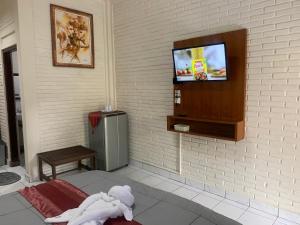 een kamer met een tv en een knuffeldier op een bed bij Dewa Bharata Bungalows Ubud in Ubud