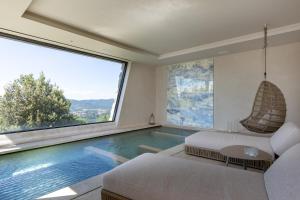 a living room with a swimming pool with a large window at I Borghi dell'Eremo in Piegaro