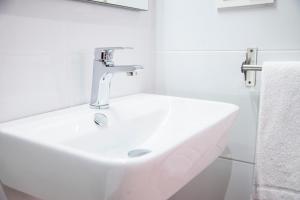 biała umywalka w białej łazience w obiekcie P4 O Grove Centro Puerto w mieście O Grove
