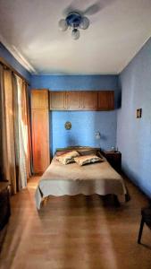 una camera con un letto con una parete blu di Kakheti Apartment a Dedoplis Tskaro