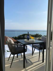 a table and chairs on a balcony with a view of the ocean at Villa Hvar II in Ivan Dolac